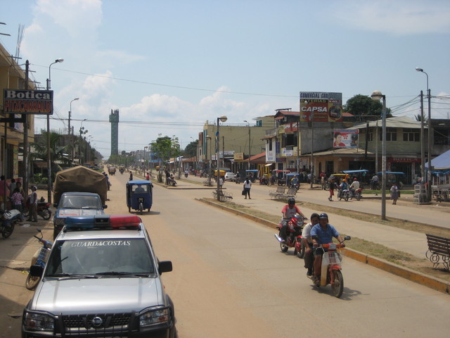 Street scene with cars, motorbikes and dust